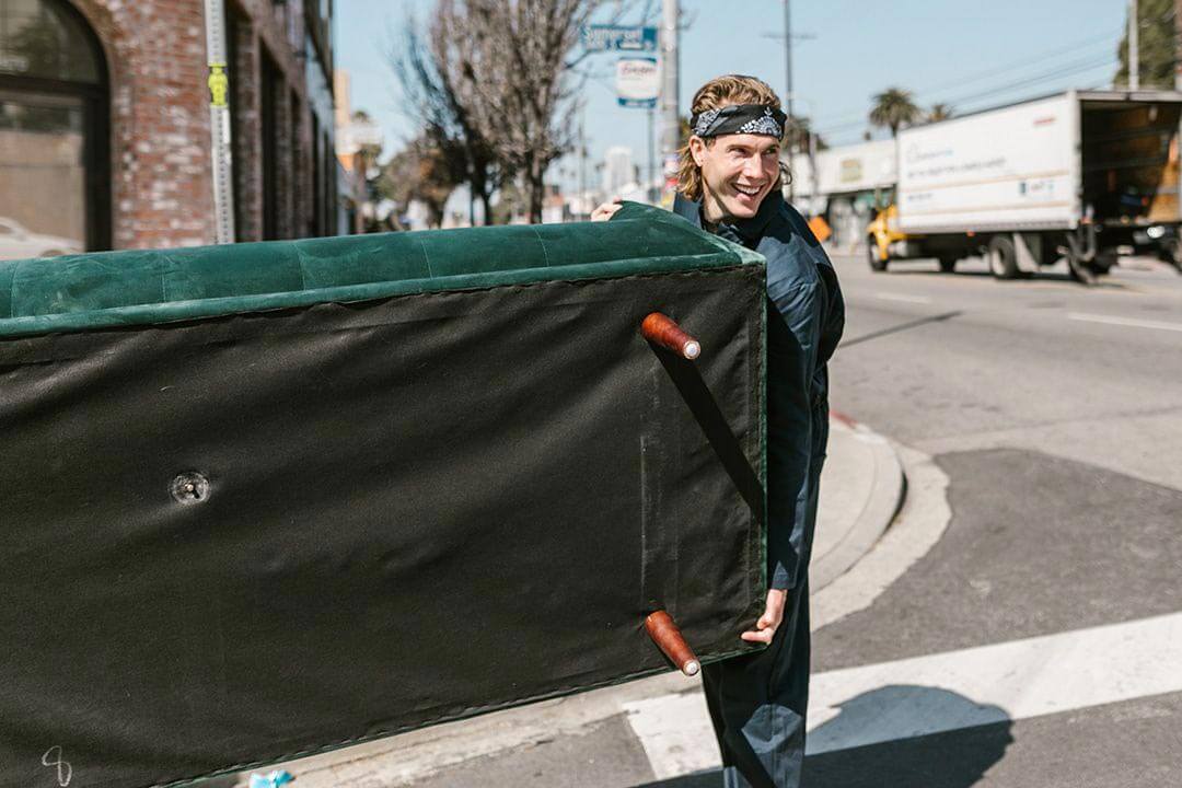 Young man helping to move a couch.