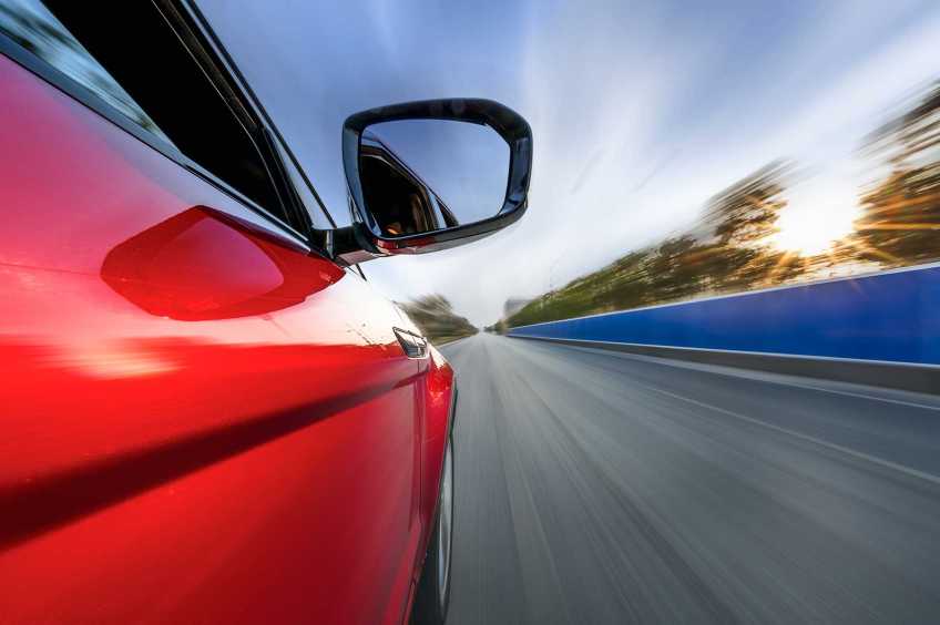 Red car driving on a racetrack.