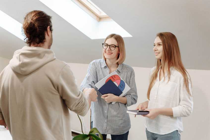 Three people smiling and shaking hands