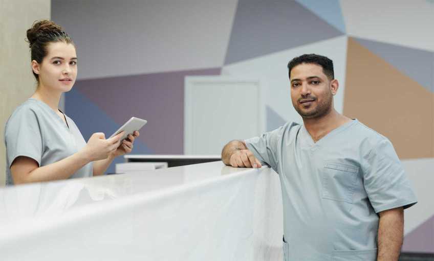 Two health care professionals talking over a counter