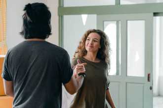 Man and woman shaking hands in doorway